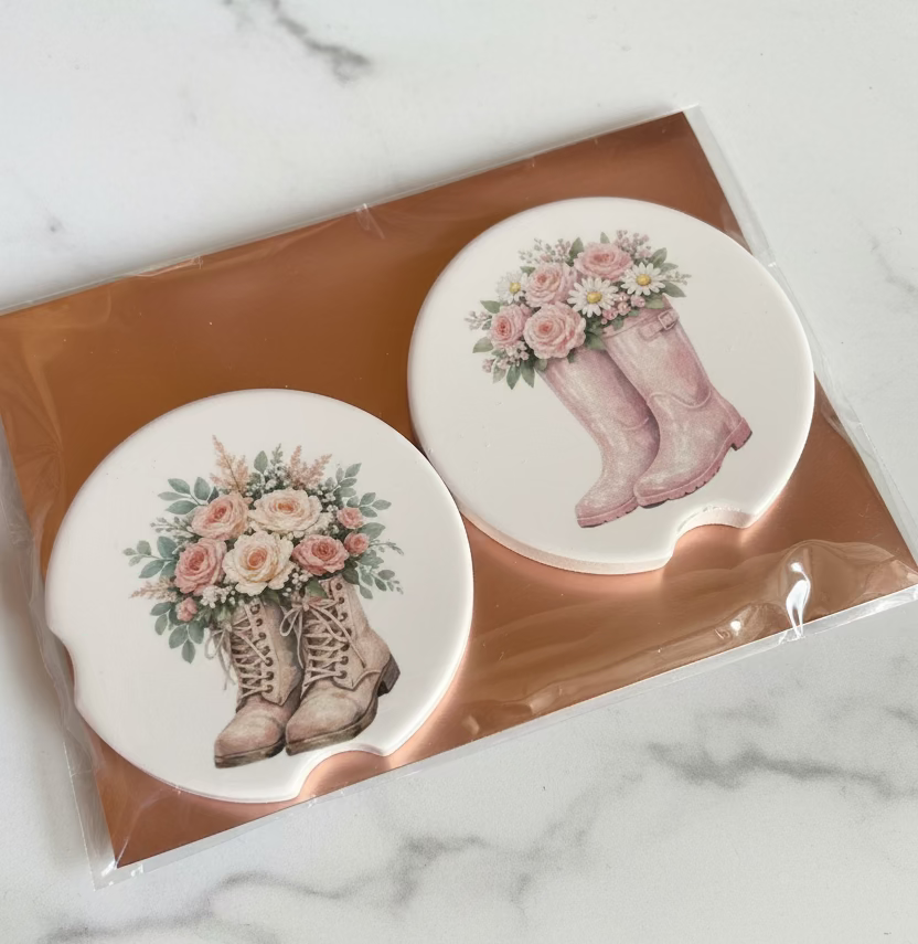 car coasters with boots and flowers on marble table background