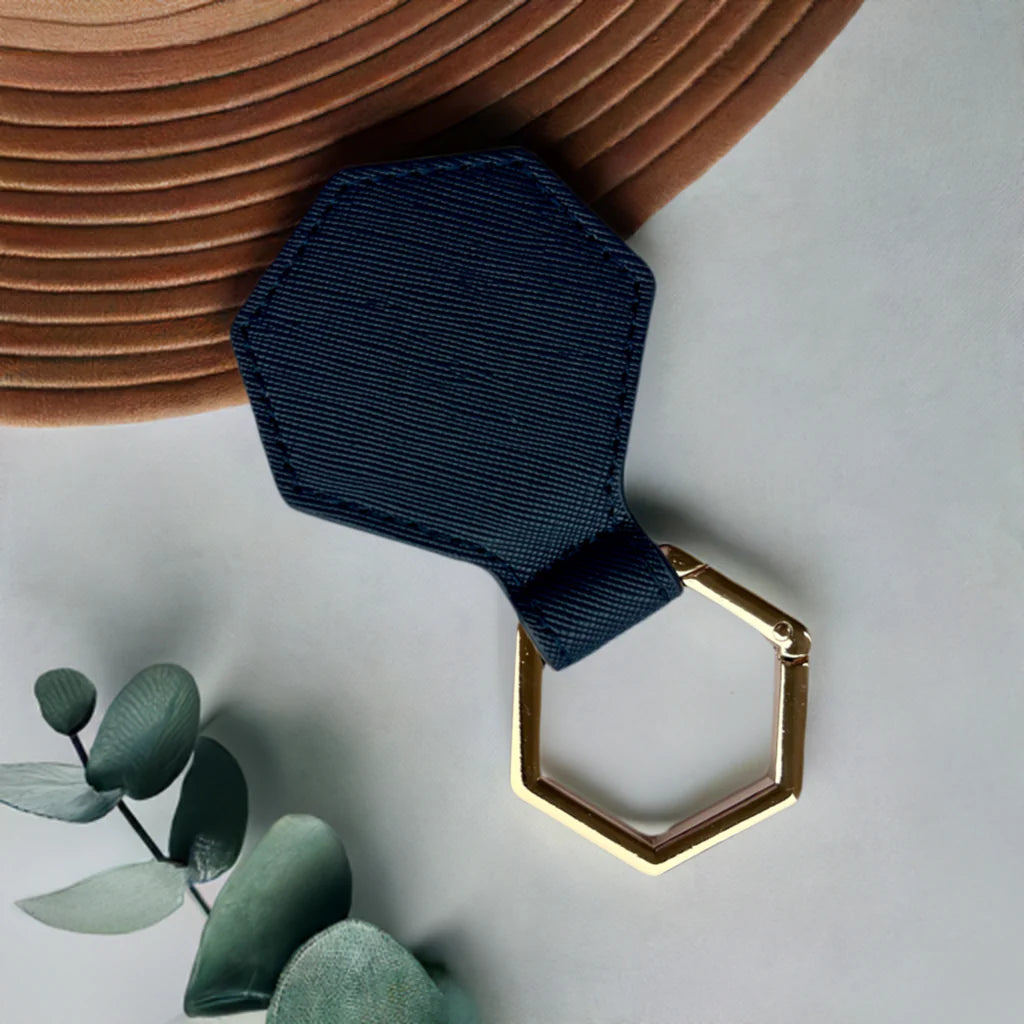 Dark blue hat clip with gold buckle on a light gray background