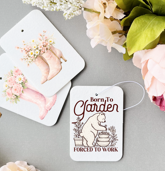 car air freshners with flowers and boots and garden saying on a grey background with flowers