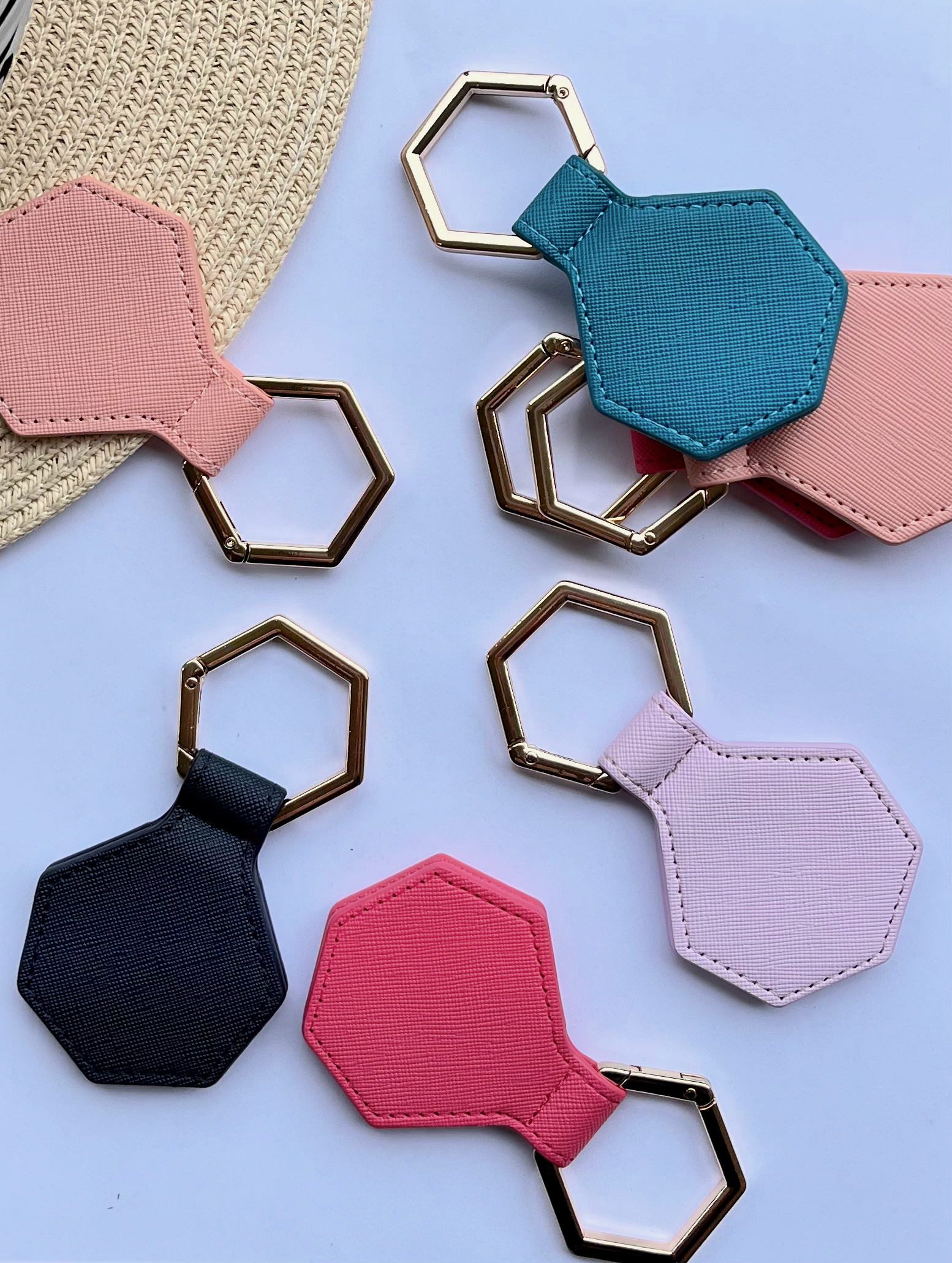 Hexagonal hat clips with gold  in various colors on a light blue background