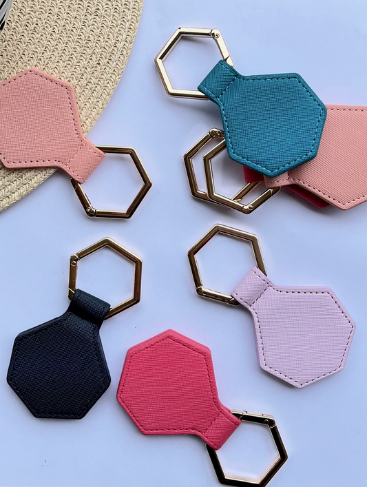 Hexagonal hat clips with gold  in various colors on a light blue background