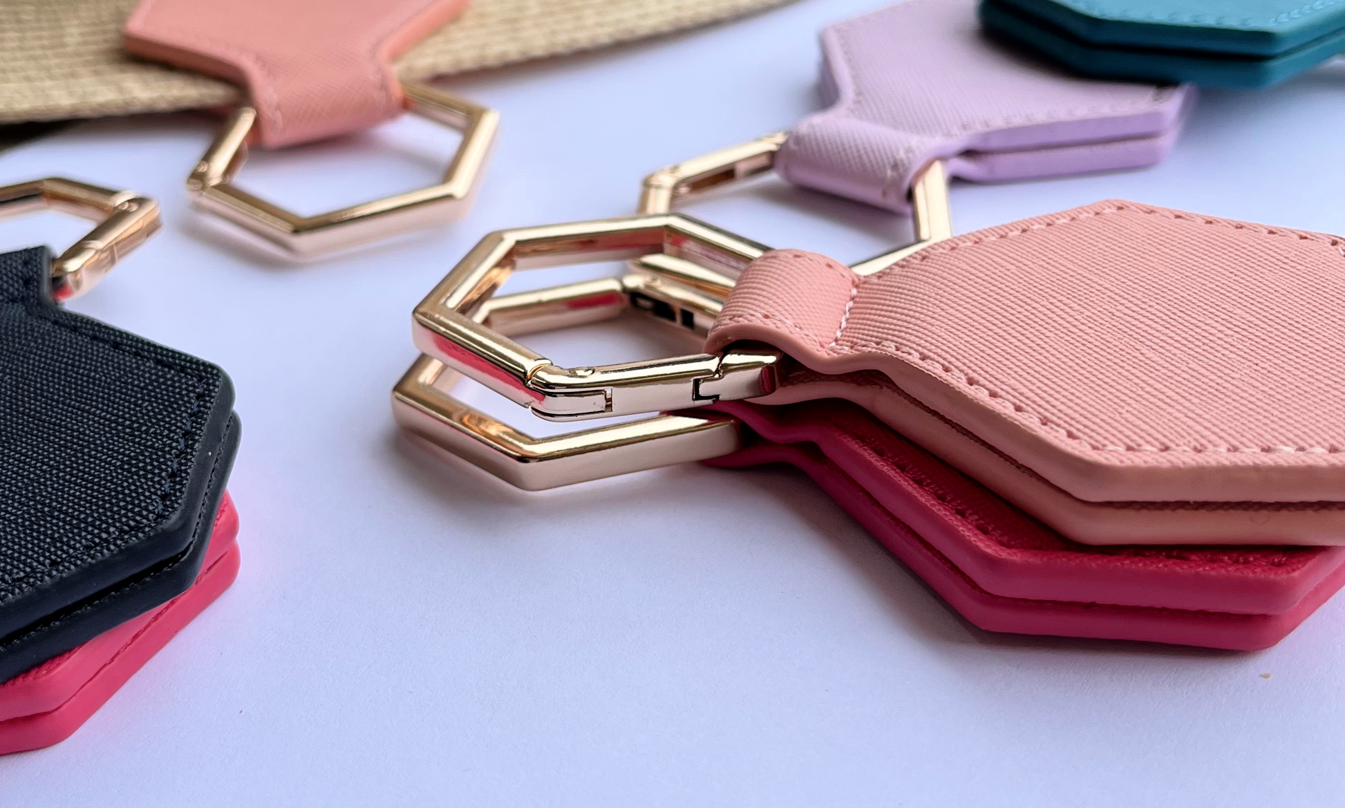 Hexagonal hat clips with gold clasps  in various colors on a white background
