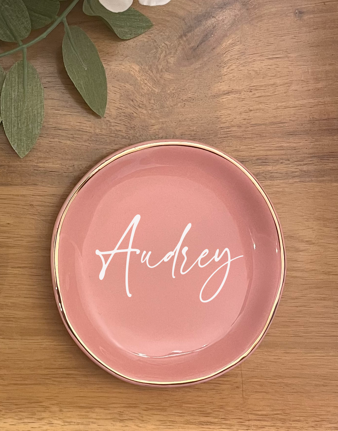 Pink ceramic dish with 'Audrey' on a wooden surface