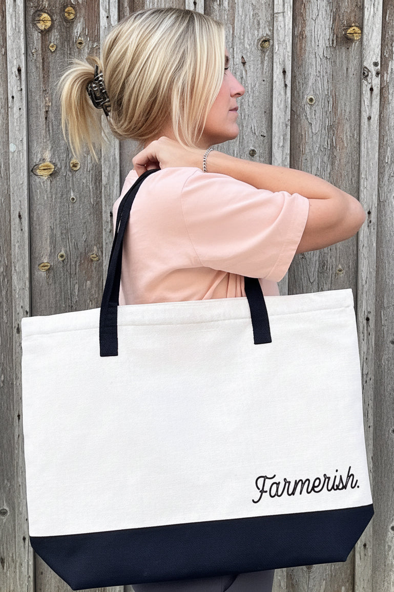 tote bag that says farmerish standing in front of a barn