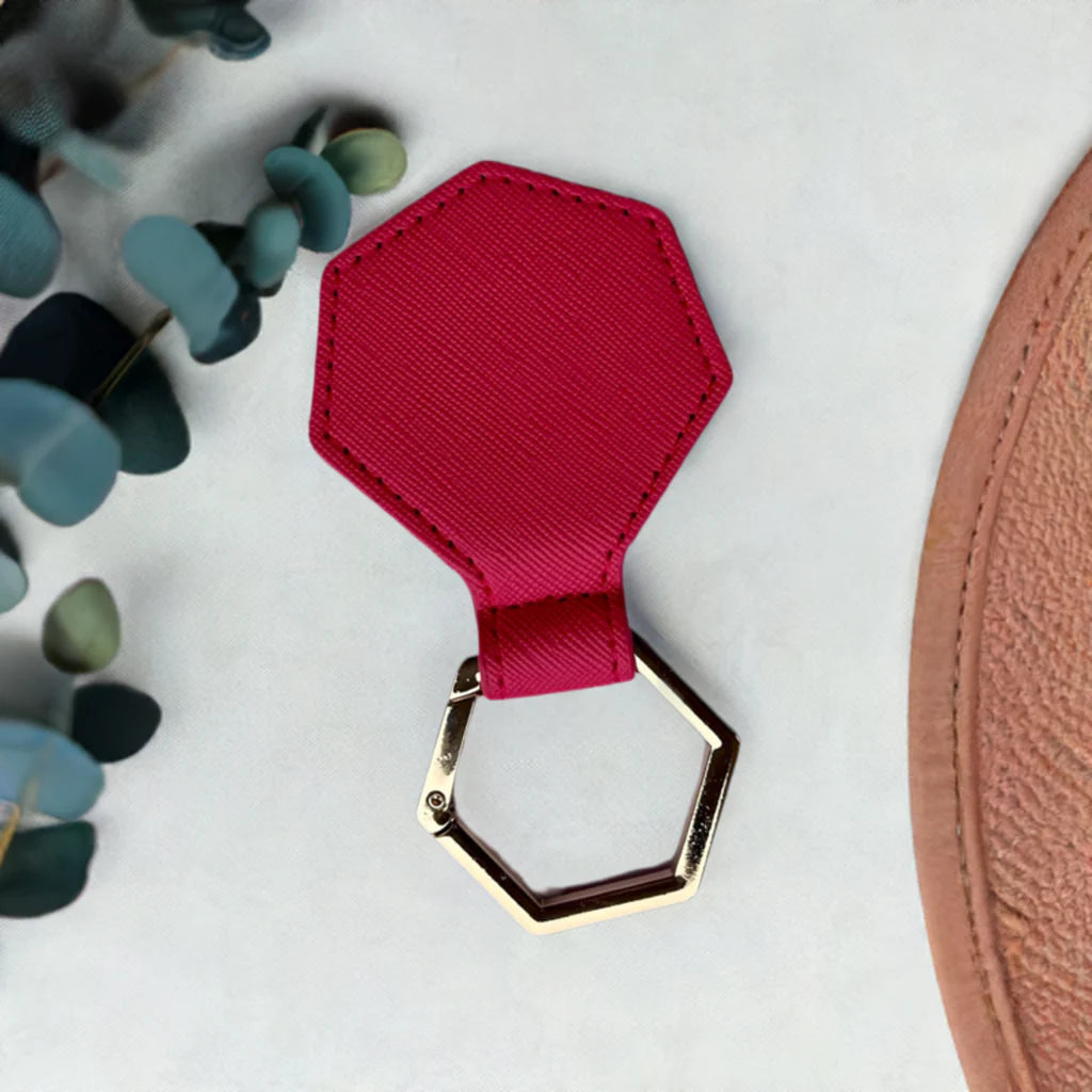 Hexagonal hat clip fuchsia and gold clasp on a light background