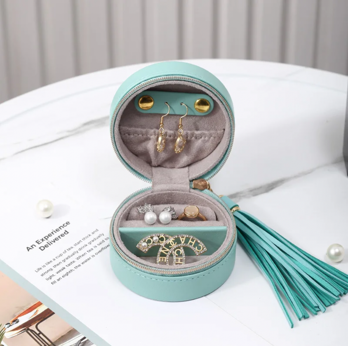 Teal jewelry box with tassel on a white surface